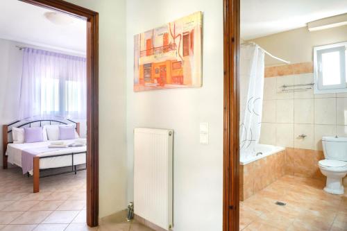 La salle de bains est pourvue de toilettes, d'une baignoire et d'un lavabo. dans l'établissement Villa Golden Nest, à Limenaria