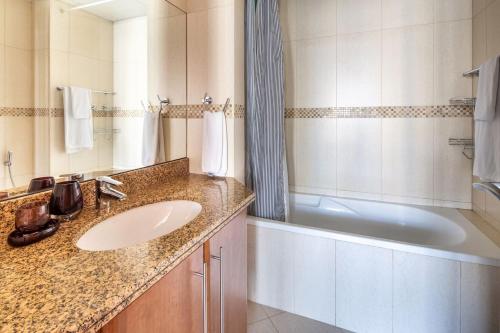 a bathroom with a sink and a bath tub at Frank Porter - Saba 3 in Dubai