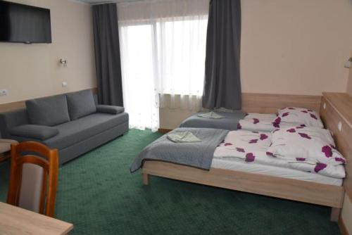 sypialnia z dużym łóżkiem i kanapą w obiekcie Willa Sole w Busku Zdroju