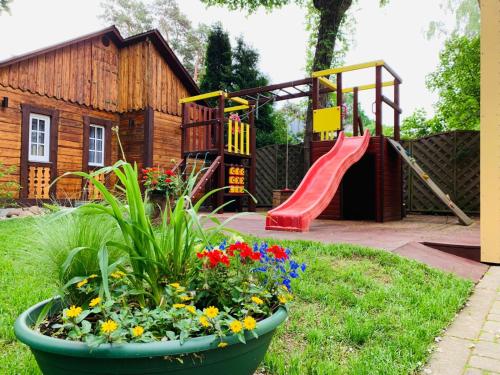 a garden with a playground with a slide and flowers at Jurmala apartment in Jūrmala