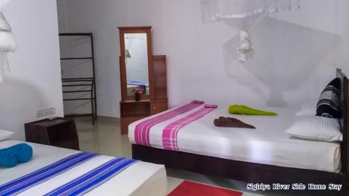 a bedroom with two beds and a mirror at The Sigiri Roar in Sigiriya