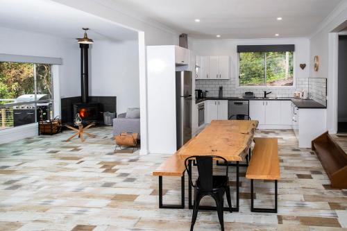 a kitchen and living room with a table and a fireplace at Warburton Digs in Warburton
