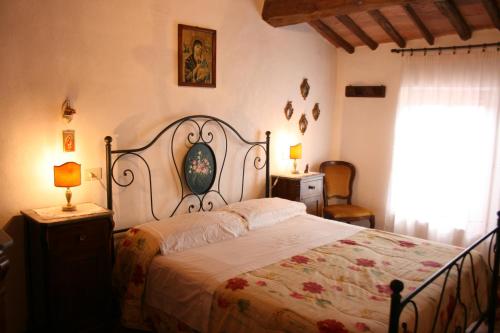 a bedroom with a large bed and a window at PODERE CAPANNE in Sinalunga
