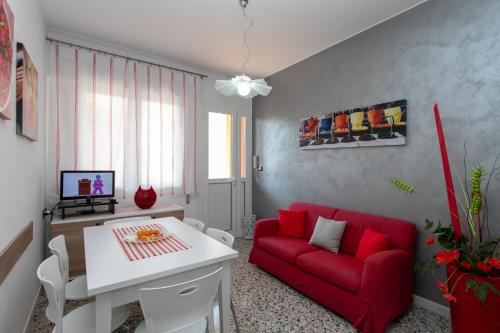 a living room with a red couch and a table at Appartamenti Bedin, JESOLO LIDO in Lido di Jesolo