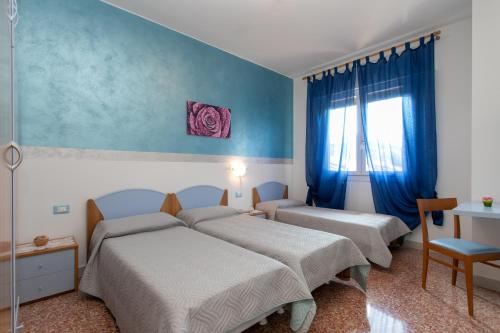 1 dormitorio con 2 camas y ventana en Appartamenti Bedin, JESOLO LIDO, en Lido di Jesolo