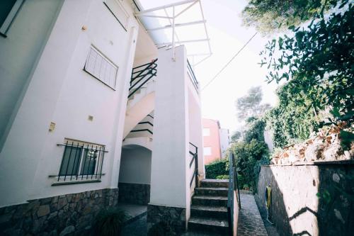 a stairway leading up to a white building with stairs at Ka Mahina a Calella de Palafrugell in Calella de Palafrugell