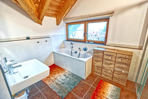 a bathroom with a sink and a bath tub at Gastl Ferienwohnung und Bootsverleih in Berg am Starnberger See