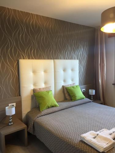 a bedroom with a large bed with green pillows at Villa Arianna Panoramic Apartments in Malcesine