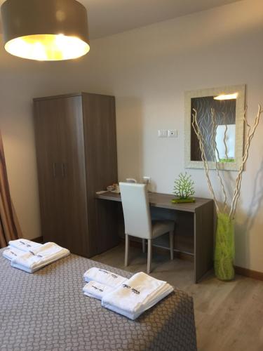 a room with a desk and a bed with towels at Villa Arianna Panoramic Apartments in Malcesine