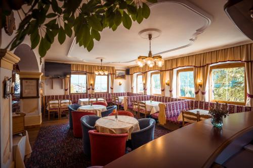 ein Restaurant mit Tischen, Stühlen und Fenstern in der Unterkunft Hotel Zita in Trins