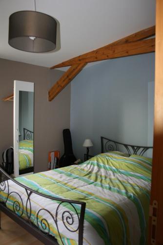 une chambre avec un lit avec une couette colorée dans l'établissement Les Petits Galets appartement DUPLEX, à Fécamp
