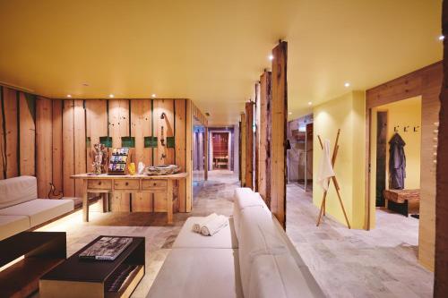Small Luxury Hotel of the World - DasPosthotel في زيل أم زيلر: غرفة معيشة مع أريكة وطاولة