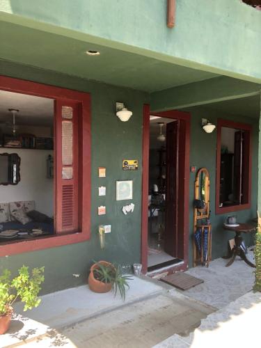 a house with a green wall and a doorway at Bergamota in Abraão