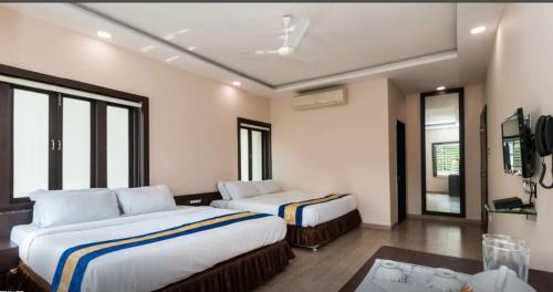 Habitación de hotel con 2 camas y mesa en The Raj Hotel and Resort en Jaipur