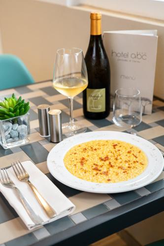 a table with a plate of food and a bottle of wine at Hotel Abc in Cervia
