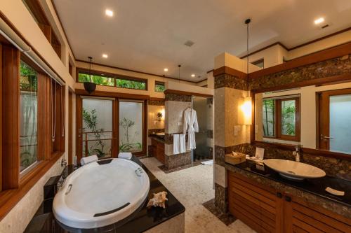 un bagno con una grande vasca e due lavandini di Serene Pavilions a Wadduwa