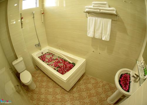 曼德勒的住宿－Hotel Homey Mandalay，浴室配有装满粉红色花卉的浴缸。