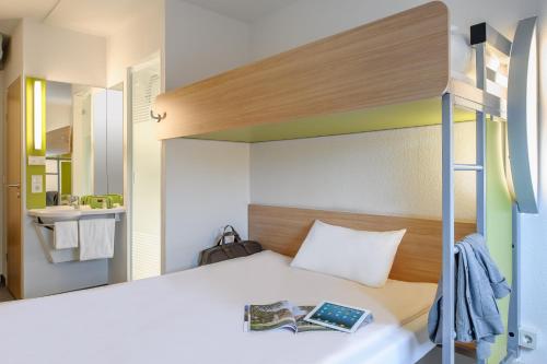 a bedroom with a bunk bed with a book at ibis budget Düsseldorf Airport in Ratingen