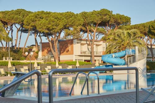 a playground with a slide next to a swimming pool at Golfo del Sole Hotel & Holiday Resort in Follonica