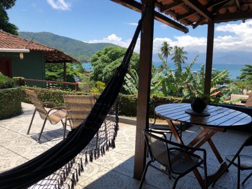 a hammock on a patio with a table and chairs at Bergamota in Abraão