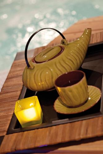 une théière, une tasse et une bougie sur un plateau dans l'établissement Hôtel Club mmv Le Panorama ***, à Les Deux Alpes