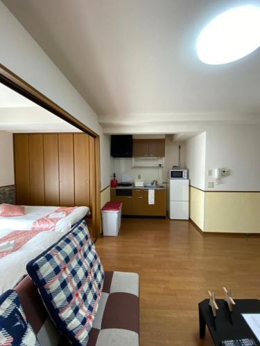 a large room with a bed and a kitchen at Laforet Tokaichi in Hiroshima