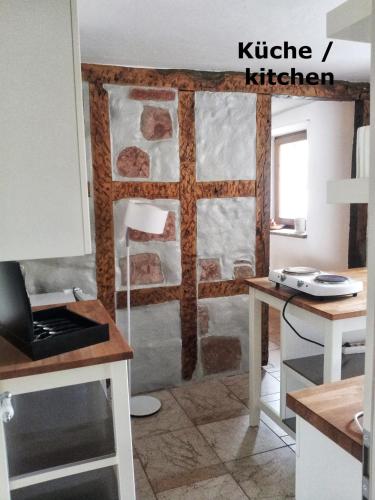 a kitchen with a stone wall and a table and a counter at Ferienwohnung VISHWAS in Trier