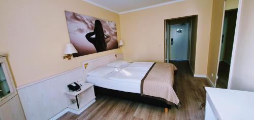 a bedroom with a bed and a painting on the wall at Park Hotel Hamburg Arena in Hamburg