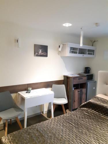 a bedroom with a bed and a table and chairs at Lana in Nida