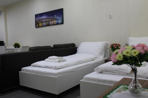 a living room with a couch and a table with flowers at Pension TV in Planá