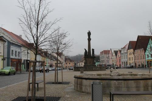 a town with a fountain in the middle of a street at Pension TV in Planá