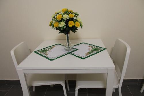 a white table with a vase of flowers on it at Pension TV in Planá