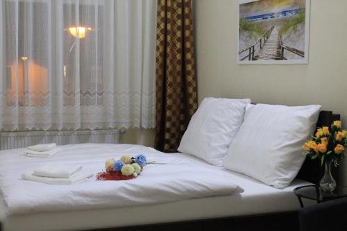 a white bed with a bouquet of flowers on it at Pension TV in Planá