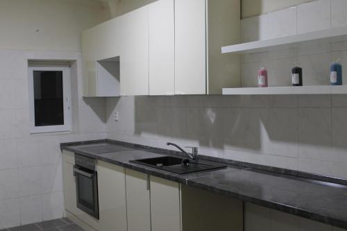 a kitchen with white cabinets and a sink at Pension TV in Planá