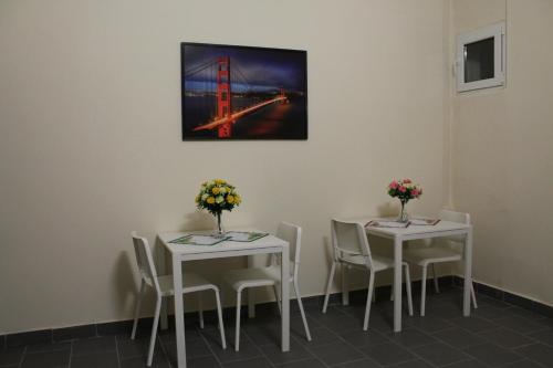 two tables and chairs with flowers on them in a room at Pension TV in Planá