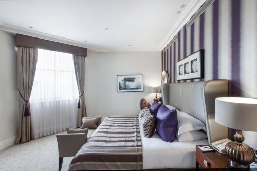 a hotel room with a bed and a window at Taj 51 Buckingham Gate Suites and Residences in London