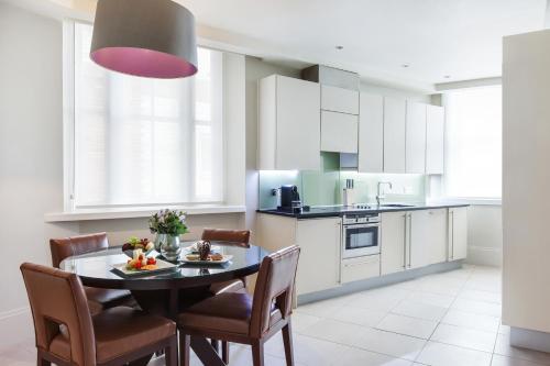 a kitchen and dining room with a table and chairs at Taj 51 Buckingham Gate Suites and Residences in London