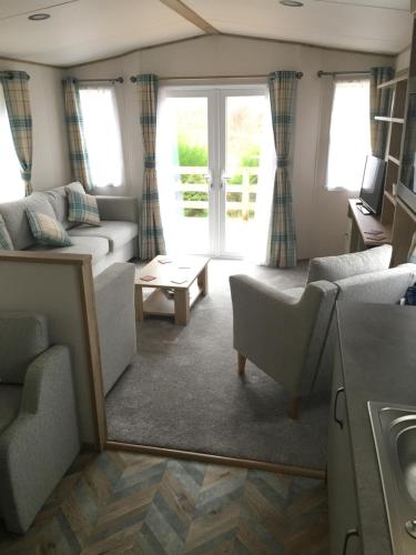 a living room with a couch and a table at Bynack Lodge in Boat of Garten