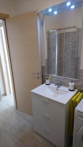 ein Bad mit einem Waschbecken und einem Spiegel in der Unterkunft Apartment Mistral in Badesi