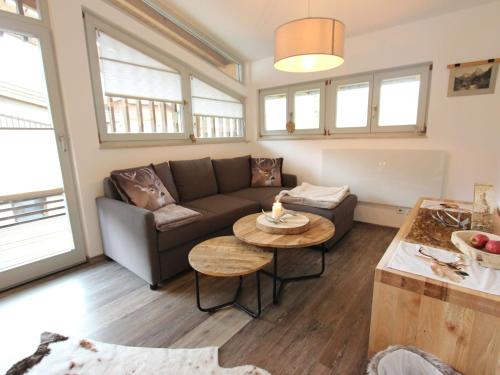 a living room with a couch and a table at Modern apartment with Wilder Kaiser view in Kirchdorf in Tirol