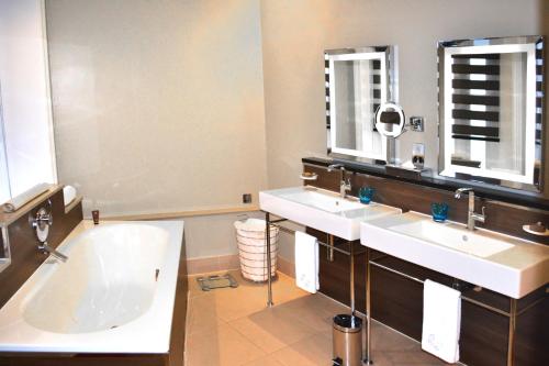 a bathroom with two sinks and a bath tub at Taj 51 Buckingham Gate Suites and Residences in London