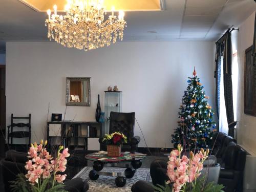 a living room with a christmas tree and a chandelier at Hotel Internazionale Gorizia in Gorizia