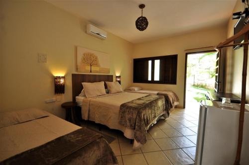 een hotelkamer met 2 bedden en een raam bij Pousada Flores do Cerrado in Pirenópolis
