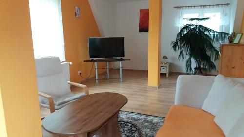 a living room with a tv and two chairs and a table at Apartmány Krásná - K68 in Jablonec nad Nisou