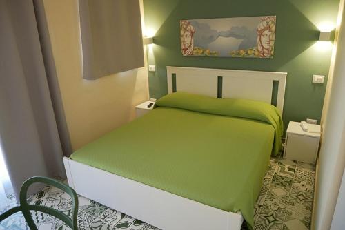 a small bedroom with a green bed in a room at villa oltremare resort in Bagheria