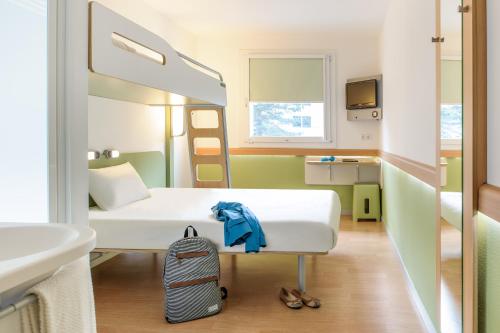 a small room with a bed and a sink at ibis budget Dresden Kesselsdorf in Wilsdruff