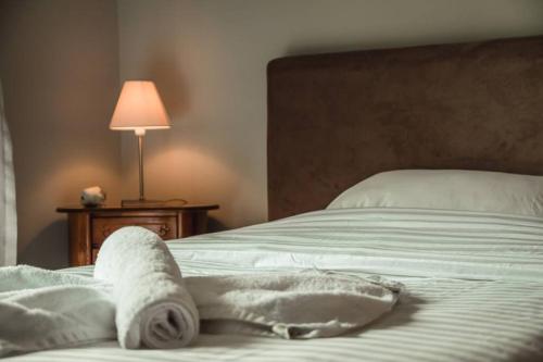 a bed with towels on it next to a lamp at API Projects Nafplio - Family Superior Apartment in Nafplio