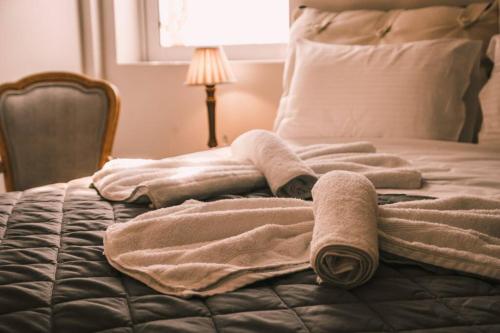 a pile of towels laying on a bed at API Projects Nafplio - Family Superior Apartment in Nafplio