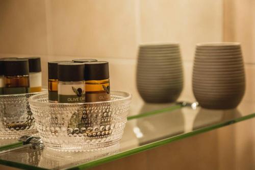 a glass counter top with cups and plates on it at API Projects Nafplio - Family Superior Apartment in Nafplio
