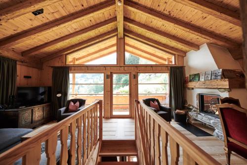 eine Holztreppe in einer Hütte mit einem großen Fenster in der Unterkunft HochLeger - Chalet Refugium am Berg in Aschau